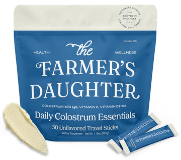 The Farmer's Daughter Daily Colostrum Essentials packaging with two travel sticks on a white background